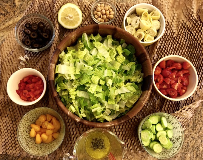 lettuce, tomatoes, cucumbers, olives, beans, red peppers, dressing, lemon, Greek salad