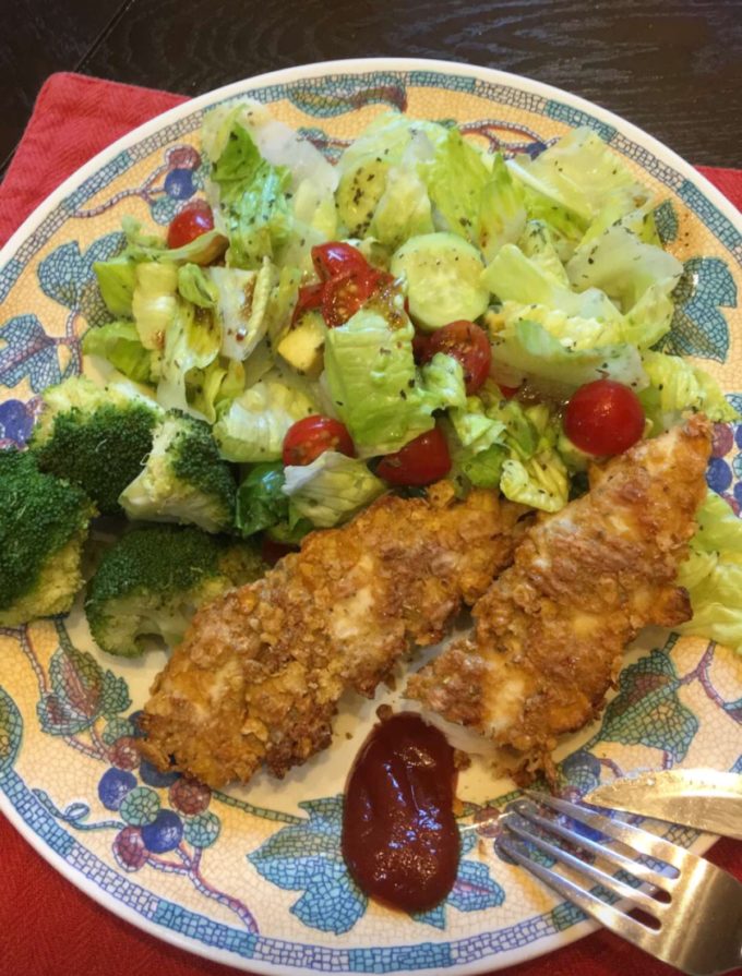 baked cornflake chicken tenders served with a side of green salad and steamed broccoli