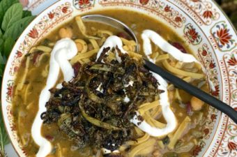 Aash Reshteh Persian Bean and Noodle Soup with Kashk or yogurt garnish and fried onion and mint topping