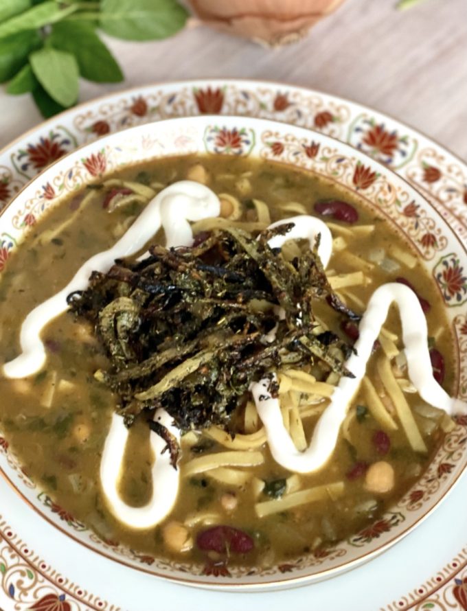 Ash Reshteh Persian Noodle Soup topped with fried onion garlic mint turmeric and kashk yogurt or sour cream