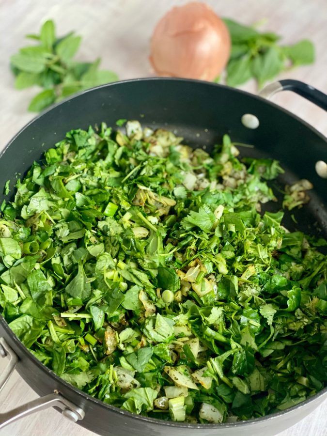 fresh herbs in a pan for making Aash Reshteh Persian Bean and Noodle Soup