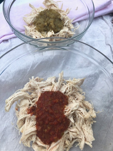 cooked shredded chicken with red and green sauce or salsa