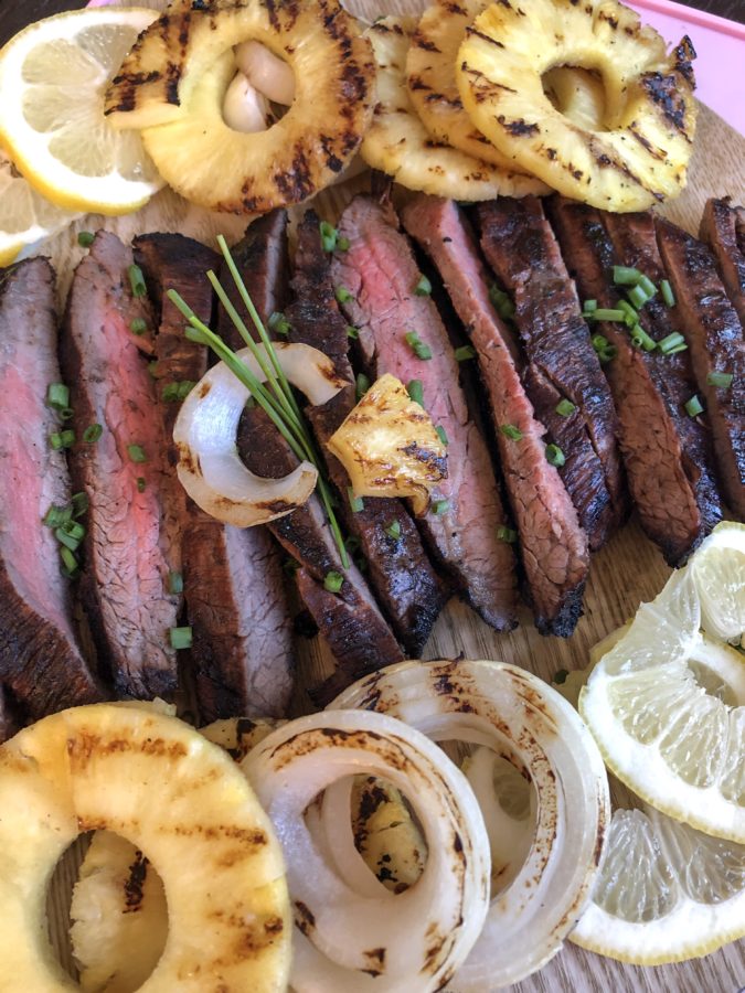 Paleo flank steak grilled with easy marinade and served with grilled pineapples and onions.