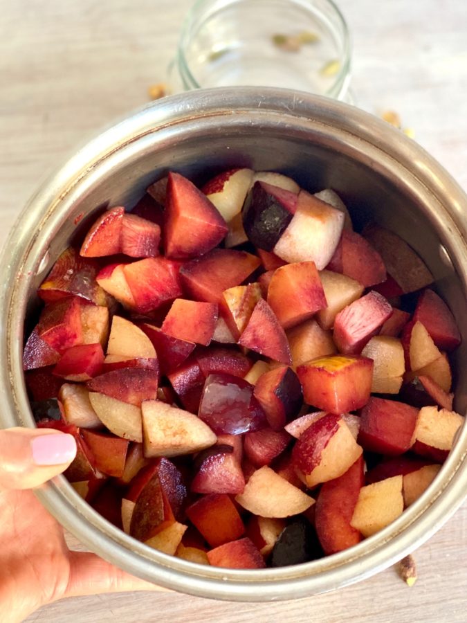 Fresh plums cut into chunks in a pot for making jam stovetop