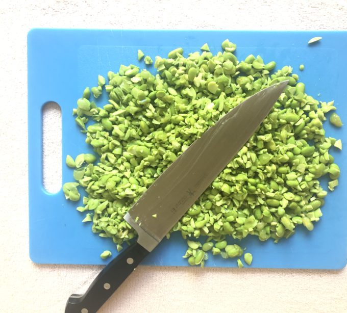 shelled edamame soy beans after a coarse chopping on a cutting board