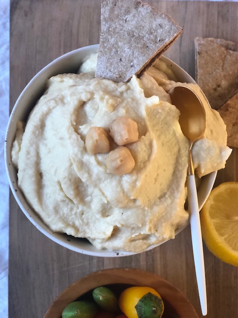 Hummus in a bowl with whole wheat pita bread