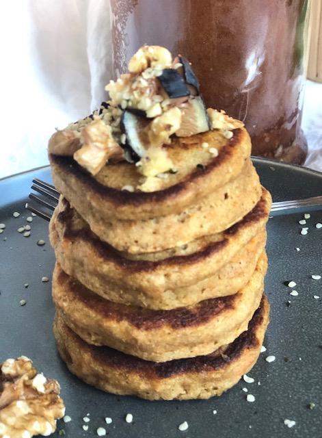 Stack of thich sweet potato pancakes topped with figs and walnuts