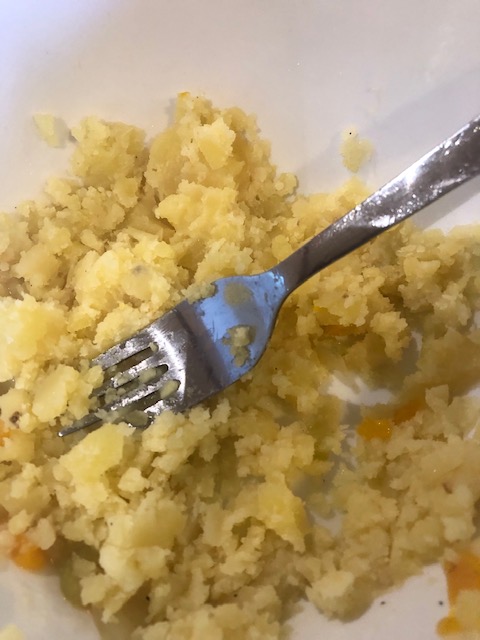 Mashing cooked potatoes with a fork