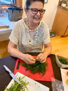 grandma trimming fresh dill for fava bean Persian rice dish